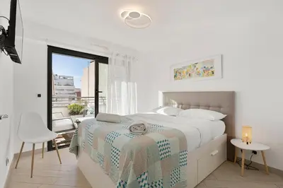 a white bedroom with a bed and a window at Suite Relax Five Stars Holiday House in Nice