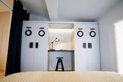 a bedroom with white cabinets and a stool in it at WAVEBNB All Confort, central, parking in Nice