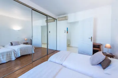 a bedroom with two beds and a glass wall at The Queen in Nice