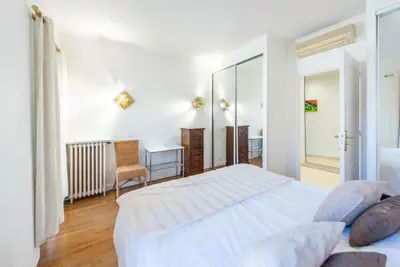 a white bedroom with a bed and a mirror at The Queen in Nice