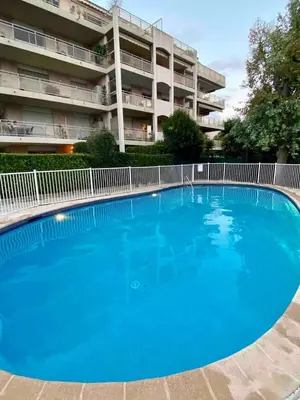 a large blue swimming pool in front of a building at Studio, piscine in Saint-Laurent-du-Var