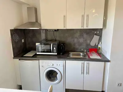 a kitchen with a washing machine and a microwave at Studio, piscine in Saint-Laurent-du-Var