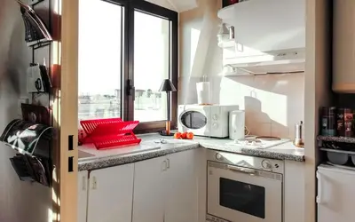 a kitchen with white cabinets and a microwave at Cosy - Negresco - AC - 5 min walk to Beach in Nice