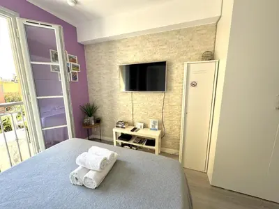 a bedroom with a bed and a tv on a wall at ApartHotel Riviera Nice Côte d'Azur - Old Town - Studio AC - Sea View - 50m Promenade des Anglais- LA MAISON LINDA in Nice