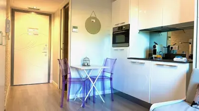 a kitchen with a table and chairs in a room at ApartHotel Riviera Nice Côte d'Azur - Old Town - Studio AC - Sea View - 50m Promenade des Anglais- LA MAISON LINDA in Nice