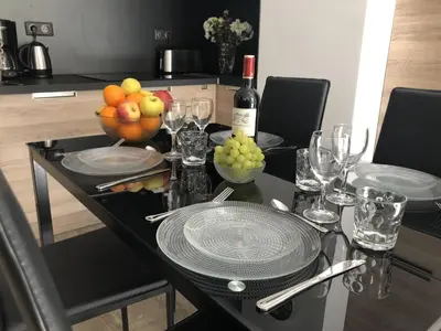 a table with a bowl of fruit and a bottle of wine at JEAN MÉDECIN - Modern Flat - Heart of center in Nice