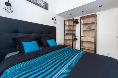 a bedroom with a large bed with blue pillows at JEAN MÉDECIN - Modern Flat - Heart of center in Nice