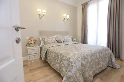 a white bedroom with a bed and a window at Le Charme-35 in Nice