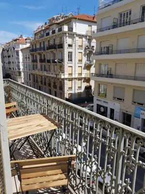 a balcony with a wooden table and some buildings at Cosy central studio Nice Rossini large balcony in Nice