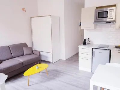 a living room with a couch and a yellow stool at Cosy central studio Nice Rossini large balcony in Nice