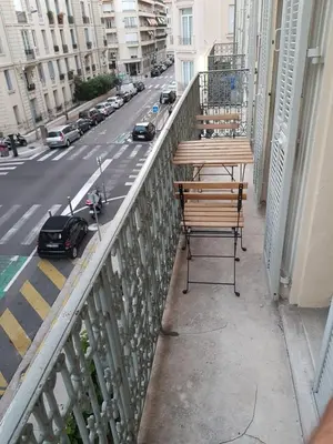 a table and chairs on a balcony with a street at Cosy central studio Nice Rossini large balcony in Nice