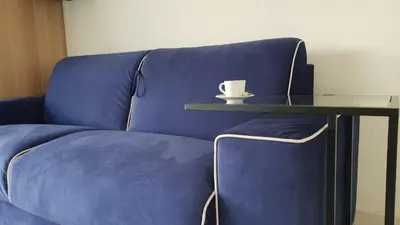 a blue couch with a coffee cup on a table at Alery apartment Nice terrace AC wifi by Affitto-Nizza in Nice