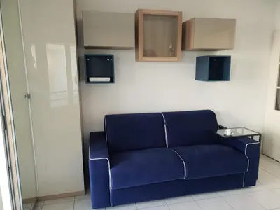 a blue couch in a room with a wall at Alery apartment Nice terrace AC wifi by Affitto-Nizza in Nice