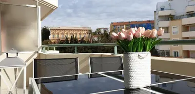 a vase of pink tulips sitting on a balcony at Alery apartment Nice terrace AC wifi by Affitto-Nizza in Nice