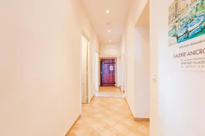 a hallway with white walls and a tile floor at ON VILLEFRANCHE BAY - AP3040 by Riviera Holiday Homes in Villefranche-sur-Mer