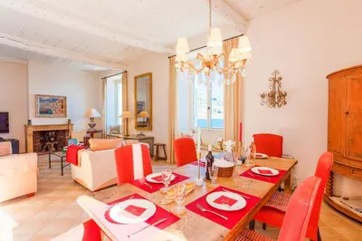 a dining room with a table and red chairs at ON VILLEFRANCHE BAY - AP3040 by Riviera Holiday Homes in Villefranche-sur-Mer