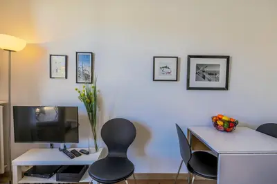 a room with a desk with a television and a table with chairs at Palais l'Escurial AP4069 by Riviera Holiday Homes in Nice