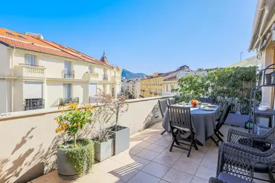 a patio with a table and chairs on a balcony at Palais l'Escurial AP4069 by Riviera Holiday Homes in Nice