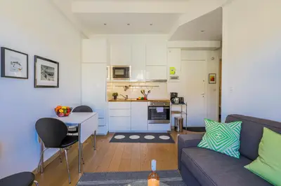a living room with a couch and a table and a kitchen at Palais l'Escurial AP4069 by Riviera Holiday Homes in Nice