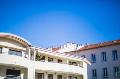 a white building with people sitting on top of it at PALAIS LIBERTE in Nice