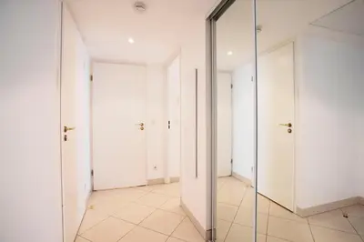 a hallway with white doors and a mirror at PALAIS LIBERTE in Nice