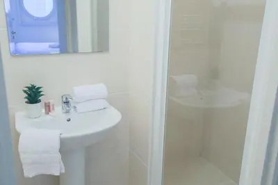 a white bathroom with a sink and a shower at PALAIS LIBERTE in Nice