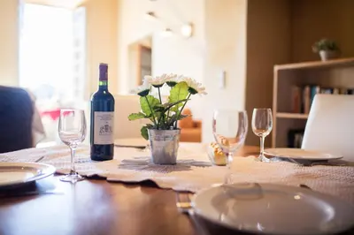a table with a bottle of wine and wine glasses at Quai des Marinières AP2015 by Riviera Holiday Homes in Villefranche-sur-Mer