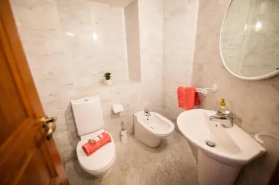 a white bathroom with a toilet and a sink at Quai des Marinières AP2015 by Riviera Holiday Homes in Villefranche-sur-Mer