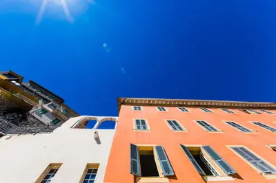 a tall orange building with windows and a blue sky at Quai des Marinières AP2015 by Riviera Holiday Homes in Villefranche-sur-Mer