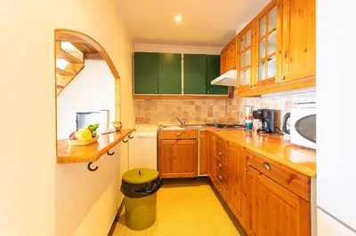a kitchen with wooden cabinets and a yellow floor at BELVEDERE AP1059 Villefranche-sur-Mer by Riviera Holiday Homes in Villefranche-sur-Mer