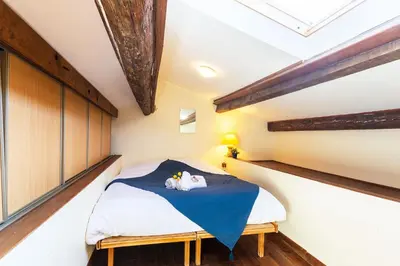 a bedroom with a bed with a blue blanket at BELVEDERE AP1059 Villefranche-sur-Mer by Riviera Holiday Homes in Villefranche-sur-Mer