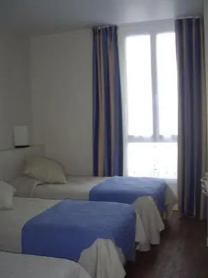 a hotel room with two beds and a window at Hotel Le Havre Bleu in Beaulieu-sur-Mer
