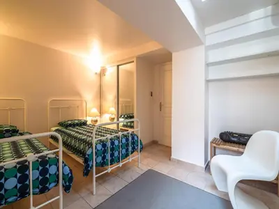 a bedroom with two bunk beds and a chair at Elegant Seaside Villa in Èze in Èze