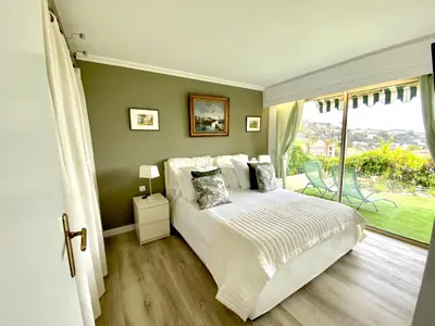a bedroom with a bed and a large window at Eden Barmassa in Villefranche-sur-Mer