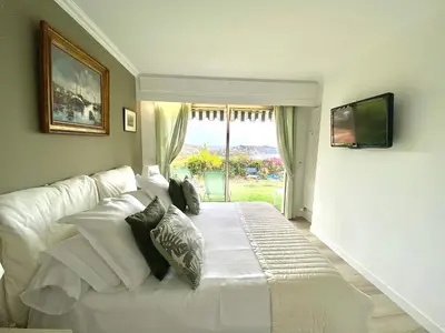 a white bed in a room with a window at Eden Barmassa in Villefranche-sur-Mer