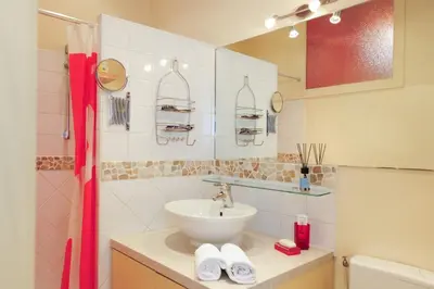a bathroom with a sink and a red shower curtain at Mini Suite Miro Five Stars Holiday House in Nice