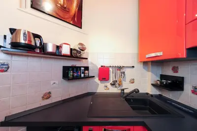 a kitchen with a sink and red cabinets at Mini Suite Miro Five Stars Holiday House in Nice