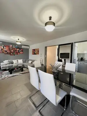 a living room with a table and white chairs at DIEGO 4 pièces duplex in Nice