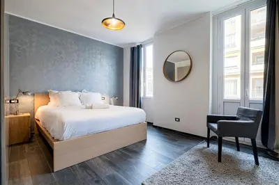a bedroom with a bed and a chair and a mirror at Nice Centre proche Mer Appartement Lumineux 6 Pers Idéal Famille Location éligible au Bail Mobilité Mobility Lease in Nice