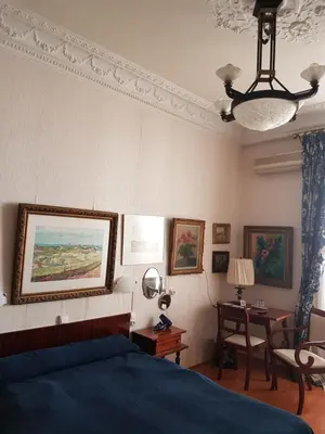 a bedroom with a bed and a table with a chair at Hotel Cronstadt in Nice
