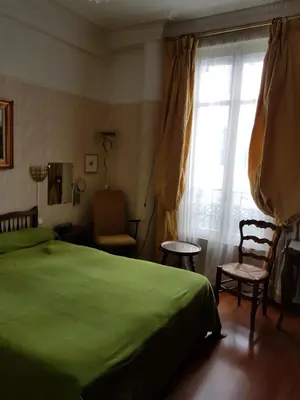 a bedroom with a green bed and a window at Hotel Cronstadt in Nice