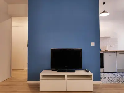 a living room with a tv on a blue wall at Best Apart - Nice Port - Balcony in Nice
