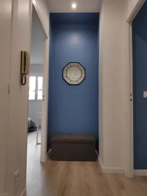 a hallway with a blue wall with a clock on it at Best Apart - Nice Port - Balcony in Nice