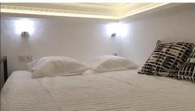 a white bed with two pillows on top of it at STUDIO DECO DESIGN, HYPER CALME in Nice