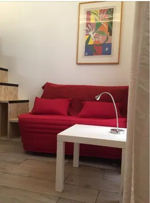 a living room with a red couch and a table at STUDIO DECO DESIGN, HYPER CALME in Nice