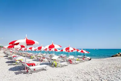 a group of chairs and umbrellas on a beach at COCOON BEACH Central Proche Mer in Nice
