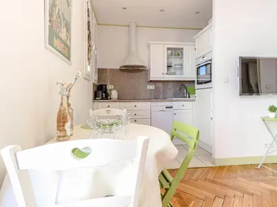 a kitchen with a table and green chairs at Apartment France by Interhome in Nice