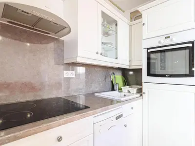 a kitchen with white cabinets and a sink and a microwave at Apartment France by Interhome in Nice