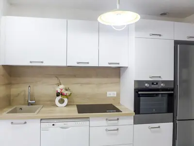a kitchen with white cabinets and a stainless steel refrigerator at Apartment Vieux Nice by Interhome in Nice