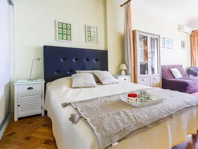 a bedroom with a large bed with a blue headboard at Apartment La Floride Promenade des Anglais by Interhome in Nice